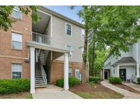 Apartment complex featuring brick and siding exterior with multiple units and stairway access, nestled among mature trees at 245 Amal Sw Dr # 2018, Atlanta, GA 30315