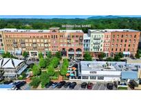 Multi-story building with visible businesses, parking, and vibrant landscaping at 360 Chambers St # 405, Woodstock, GA 30188