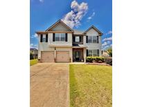 Two-story home with two-car garage, manicured lawn, and brick-accented entryway at 520 Harmony Way, Locust Grove, GA 30248