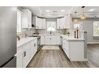 Bright kitchen with white cabinets, stainless steel appliances, and a peninsula island at 1406 Kennesaw Nw Dr, Atlanta, GA 30318