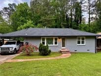Charming single-story home featuring a brick facade, well-manicured lawn, and a convenient covered parking area at 2107 Garden Cir, Decatur, GA 30032
