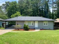 Charming gray home features a lush, well-manicured lawn and welcoming entrance with tasteful landscaping at 2107 Garden Cir, Decatur, GA 30032