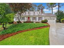 Charming Cape Cod home with a manicured lawn, red front door, and attached two car garage at 4333 Collingham Ne Trce, Marietta, GA 30068
