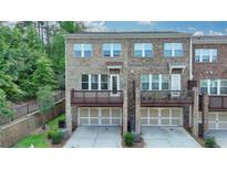 Beautiful brick townhome featuring a two-car garage and an upper level walk-out deck at 747 Topsail Ln, Alpharetta, GA 30005