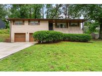 Charming brick ranch home featuring an attached two-car garage and well-maintained lawn at 900 Fleetwood Cir, Atlanta, GA 30311