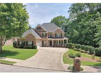 Beautiful two-story brick home featuring a well-manicured lawn, attached garage, and a cozy covered front porch at 4895 Smokestone Dr, Douglasville, GA 30135