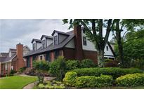 Charming brick home featuring dormer windows, lush landscaping, and a welcoming entrance at 2747 Livsey Trl, Tucker, GA 30084