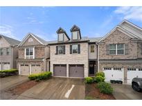 Charming brick townhome featuring a two-car garage and well-maintained landscaping at 2069 Brightleaf Way # 123, Marietta, GA 30060