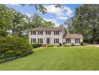 Traditional two-story home with a lush front lawn and mature trees providing shade and curb appeal at 4179 Westchester Ne Xing, Roswell, GA 30075
