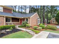 Charming brick townhouse with well-manicured landscaping and inviting front entrance at 49 Country Ct, Alpharetta, GA 30005