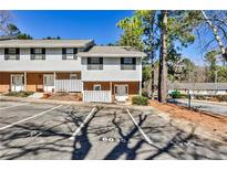 Charming townhouse showcasing a brick and siding facade with well-maintained landscaping and convenient parking at 6035 Wintergreen Rd, Norcross, GA 30093