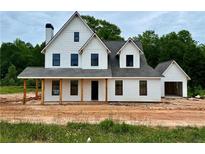 New construction home with white siding, black trim, and welcoming front porch at 95 Old Town Rd, Dacula, GA 30019