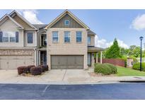 Charming two-story townhome with a brick facade, a two-car garage, and manicured landscaping at , Lawrenceville, GA 30044