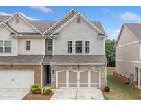 Charming townhouse with brick and siding exterior, featuring a two-car garage and well-maintained landscaping at 109 Camden Park Dr, Woodstock, GA 30188