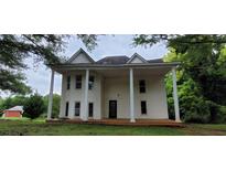 Two-story home featuring a large front porch supported by stately columns at 119 E Johnson St, Temple, GA 30179