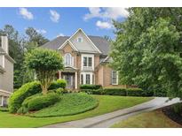 Charming two-story brick home with manicured lawn and lush landscaping, creating a welcoming curb appeal at 3665 Pennington Rd, Cumming, GA 30041