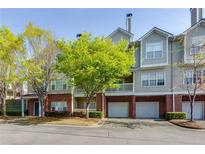 Charming multi-story townhouse with well-maintained landscaping and attached garages at 8020 Woodland Ln, Alpharetta, GA 30009