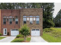 Brick townhome exterior with garage, front yard, and beautiful, timeless architectural details at 90 Grove Park Ln, Woodstock, GA 30189