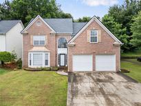 Charming brick home with a well-manicured lawn and a two-car garage at 4188 Cookcreek Place Northwest Nw Pl, Lilburn, GA 30047