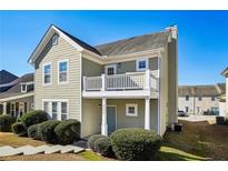 Charming two-story home with a balcony, light green siding, a well-manicured lawn and a blue front door at 4593 Parkway Cir, Atlanta, GA 30349
