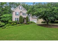 Charming two-story home featuring a well-manicured lawn and mature landscaping providing great curb appeal at 11280 Brookhollow Trl, Alpharetta, GA 30022