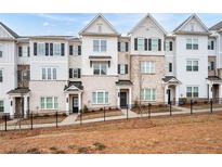 Charming townhomes feature light brick exteriors, complemented by black shutters and a decorative iron fence at 3322 Cranston Ln, Kennesaw, GA 30144