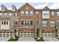 Beautiful brick and stone townhome with well-maintained landscaping and attached garages at 4104 Townsend Ln, Dunwoody, GA 30346
