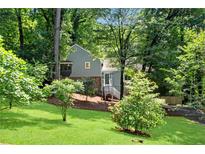 Charming home with a well-maintained front yard and mature trees, creating a serene setting at 3726 Scotts Mill Run, Peachtree Corners, GA 30096