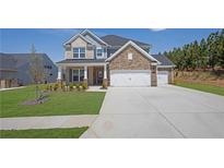 Two story home with mixed stone and vinyl siding, manicured lawn and 3-car garage at 307 Ernest Ave, Peachtree City, GA 30269