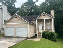 Two-story home with attached two-car garage, front porch with columns, and neutral siding at 4963 Windsor Downs Ln, Decatur, GA 30035