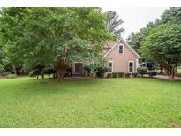 Charming home with a well-manicured lawn and mature trees enhancing its curb appeal at 155 Redspire Ln, Fayetteville, GA 30215