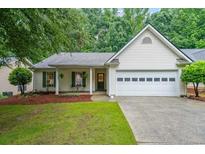 Charming one-story home with a well-manicured lawn, attached garage and an inviting front porch at 3318 Freedom Lndg, Kennesaw, GA 30144