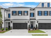 Charming townhome showcases a light brick facade, black trim, garage, and manicured lawn at 709 Dodd Ln # 165, Buford, GA 30518