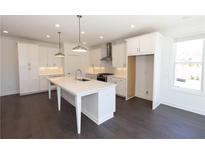 Bright kitchen featuring white cabinets, stainless steel appliances, and an island with a quartz countertop at 709 Dodd Ln # 165, Buford, GA 30518