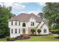 Elegant two-story home featuring a stone accent, manicured lawn, and a welcoming entrance at 5535 Buck Hollow Dr, Alpharetta, GA 30005