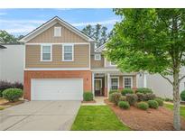 Charming two-story home with a well-manicured lawn, a two-car garage, and a welcoming front entrance at 728 Lorimore Pass, Canton, GA 30115