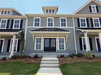 Charming two-story townhome featuring a covered entrance, double doors, and well-manicured landscaping at 1741 Prospect Way, Conyers, GA 30094
