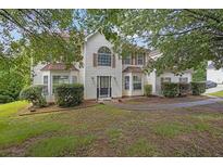 Charming two-story home with light siding, complemented by well-manicured hedges and a welcoming entrance at 3885 Riverview Chase Blf, Ellenwood, GA 30294