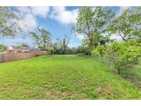 Spacious backyard features lush green grass and chain link fence with shade trees along the border at 1338 Georgia Ave, Atlanta, GA 30344
