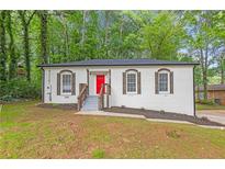 Charming, renovated brick ranch home with red front door and new landscaping at 4698 Fellsridge Dr, Stone Mountain, GA 30083