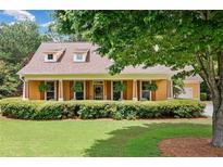 Charming home with a welcoming front porch, dormer windows and well-manicured landscaping at 221 Creekside Pass Pass, Canton, GA 30114
