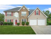 Charming two-story home with a manicured lawn, red shutters, and a stone facade at 60 Heaton Dr, Covington, GA 30016