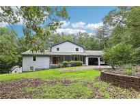 Charming home featuring a covered front porch, attached garage, and beautifully landscaped front yard at 8464 Pleasant Hill Rd, Lithonia, GA 30058