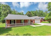 Charming brick home with a well-maintained lawn and a inviting front porch at 5514 E Stoneway Ct, Villa Rica, GA 30180
