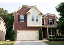 Two-story brick home with attached garage and manicured lawn at 3020 Whitfield Ave, Cumming, GA 30040