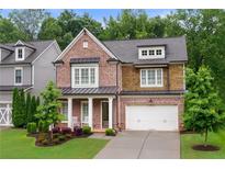 Charming brick home with a covered front porch, manicured landscaping, and a two-car garage at 281 Green Hill Rd, Atlanta, GA 30342