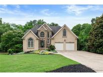 Charming two-story home with stone accents, a well-manicured lawn, and a two-car garage at 2314 Tall Timbers Ln, Marietta, GA 30066