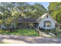 Charming light blue home nestled on a lush lot with mature trees and welcoming front porch at 2371 Leguin Mill Rd, Locust Grove, GA 30248