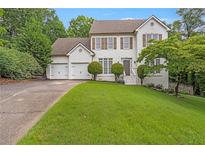 Charming two-story home features a well-manicured lawn and a two-car garage at 4865 Chesterfield Ct, Suwanee, GA 30024