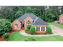 Beautiful brick home with manicured lawn, professional landscaping, and mature trees offering curb appeal at 8108 Greens Mill Way, Loganville, GA 30052
